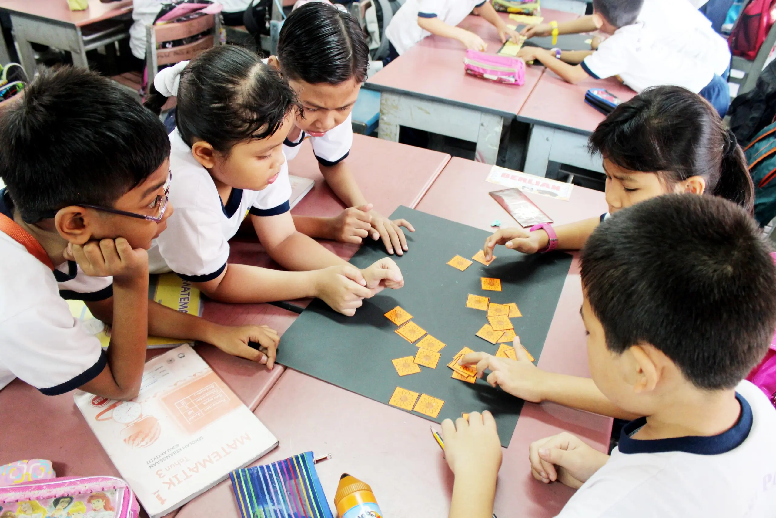Primary school pupils working with letter cards at a table